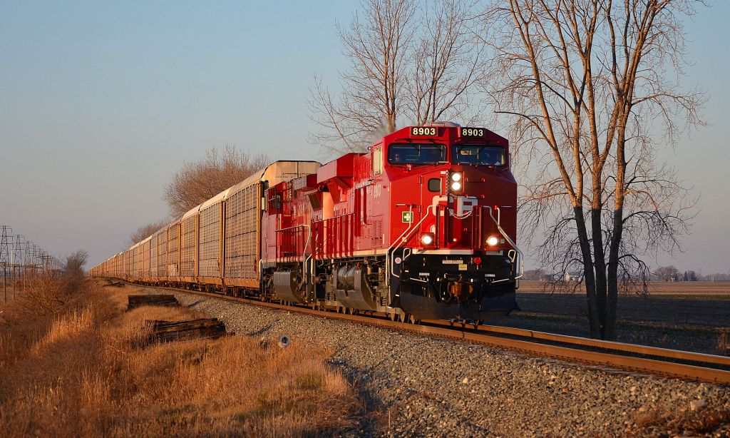 Brand new CP 8903 and ex Unstoppable 9777 lead this long autorack train eastbound in the early morning December sun.