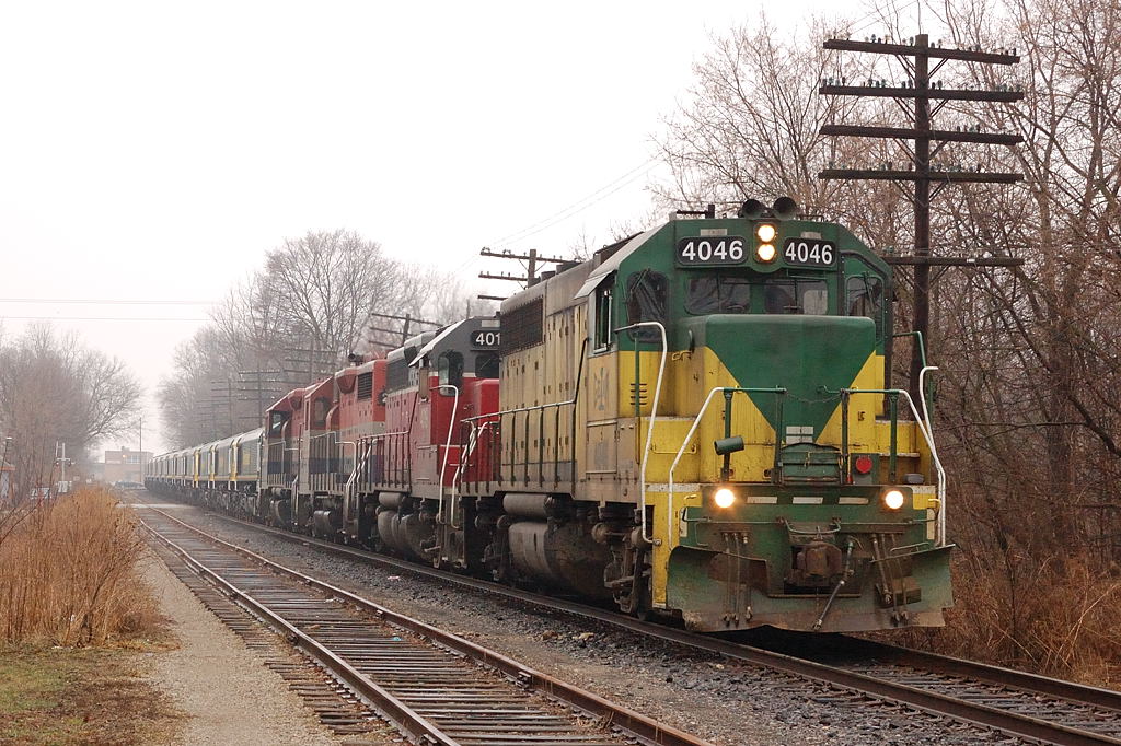 GEXR X432 rolls through residential downtown Guelph with an export train of locomotives destined for Britian. On this grey, foggy and wet day in charge of the train were GEXR GP40-2 4046-GEXR GP40 4019 - RLK GP35 2210- RLK GP40 40496.