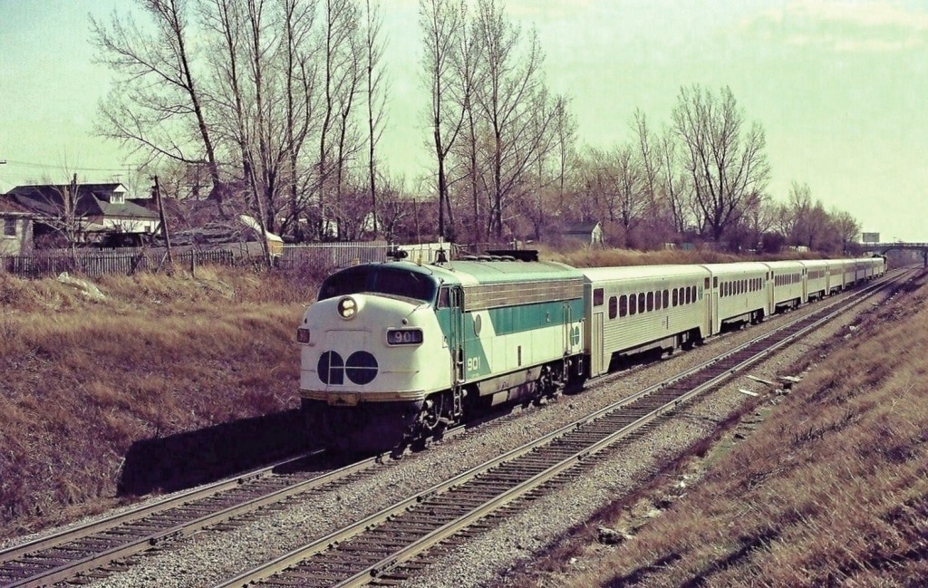 The first twelve years or so GO Transit was a rather modest operation, Lakeshore route Pickering to Oakville only. Ten car GO Trains were week day rush hour only, off peak and weekend service was  sparsely patronized and handled by two or three car self propelled Hawker Siddeley built units ( pics out there by anyone?) numbered in the \'D\' series (D100 to D108). At that time almost all GO equipment was new, except for the rebuilt ACPU ex ONR F units, so with GO basically uninteresting these negatives were exposed while waiting for Via CN Rapidos\', Bonaventures\', Execs\', Capitals\' powered by  Cab Units: FPA4\'s and FP-9A\'s that could be in either new Via colours or even better in the CN stripes – by far more interesting. So for a spring Saturday operation these ten car Go Trains was a surprise. The reason for the Saturday (and Sunday) rush hour sized trains: increased patronage generated due to the new Major League Baseball team\'s home games at Exhibition Stadium – the rest of course is history but certainly credit the Major League for the public discovering the convenience of using GO for pleasure travel, in addition to the standard daily Monday to Friday business travel grind. The hourly GO schedule provided a \'meet\' between Danforth and Scarborough Stations, so these negatives (compete with unexpected colour shift – minor correction attempted) with 700 and 901 leading respective westbound and eastbound trains were exposed June 1977, only minutes apart, near the top of the Scarborough grade (eastbound uphill). And this GO equipment is not new now, it is history. So, the first twelve years or so of GO looked like this. ASA100 Kodak colour negatives transported by a Nikon Nikkormat EL. Photographer S. Danko.