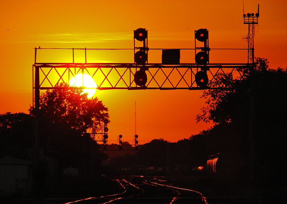 I\'ve always been a stickler for sunrise/sunsets and this one is no different, the sun begins to set in the red western sky behind the signals that guard westward train movements onto the Galt Sub from the North Toronto Sub.