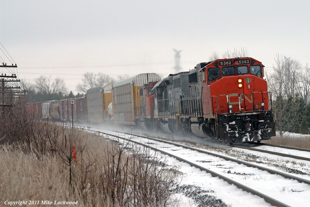 Headlights dimmed, CN 368 behind CN 5362, GTW 5949, and CN 4774 is about to pass the stopped 305 on a blustery late autumn day. Of the four CN freights I caught in a couple hours trackside, this was the only train not lead, or completely powered by, new 8800 series SD70M-2s. Thinking back, this was the real beginning of the end of these types of lashups out on the Kingston Sub, as now just about everything is powered by pairs of 4000-4400 HP locomotives. The stopped 305 not seen in the photo was powered by two of them with a GP38-2 along for the ride. 1434hrs.
