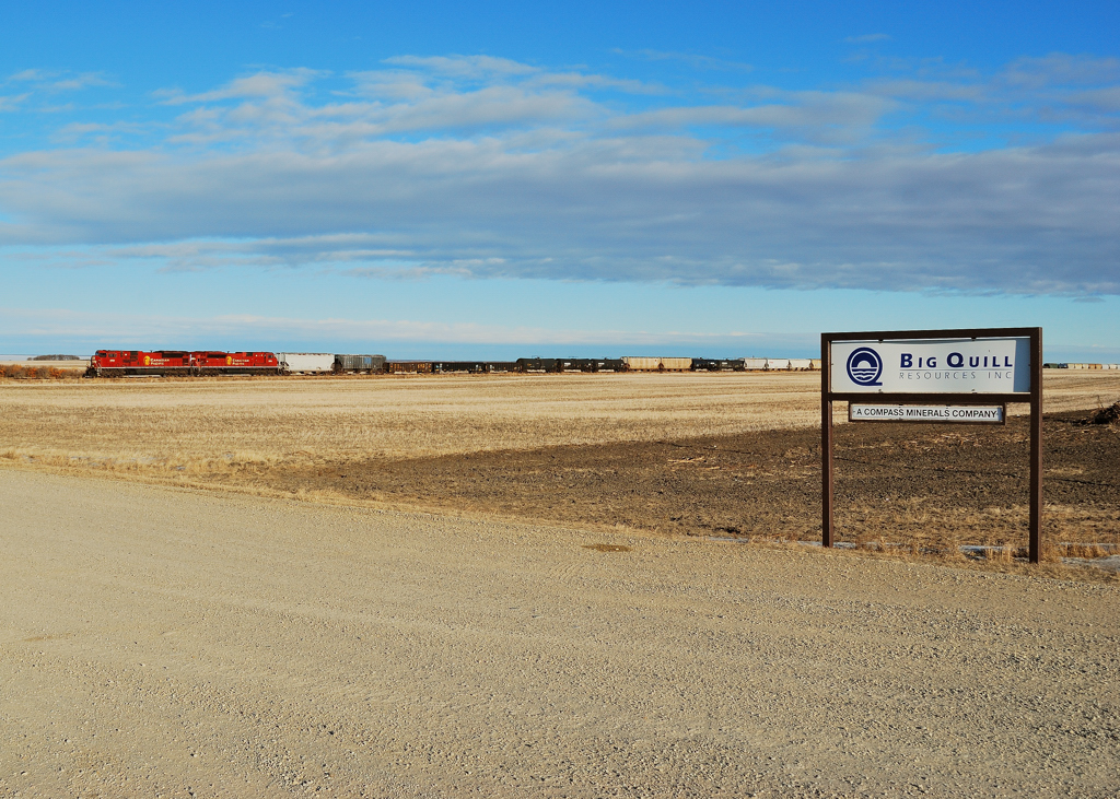 Trying to make it home in time for Christmas a pair of 90 macs hustle westbound past the sign to Big Quill resoucres on the shore of Big Quill Lake.