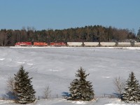 On a cold and clear day, CP 3113, 8234, and 3043 lead a 24 car T07 across a frozen landscape west of Burketon, Ontario. The SOO 116***-117*** series covered hoppers were mainstays of Unimin traffic for a number of years, however they disappeared from the line in late spring 2011, replaced with leased brand new CEFX and GACX two bay cars. The NCHX cylindrical cars carrying Indusmin lettering, mostly built in 1975, continue to ply the line, however. 1025hrs.