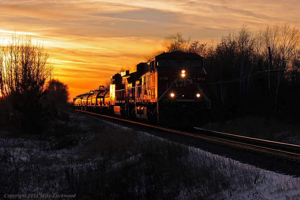 The setting sun glints off the side of CP 8726 and 9656 as they take train 232 east. 1704hrs.