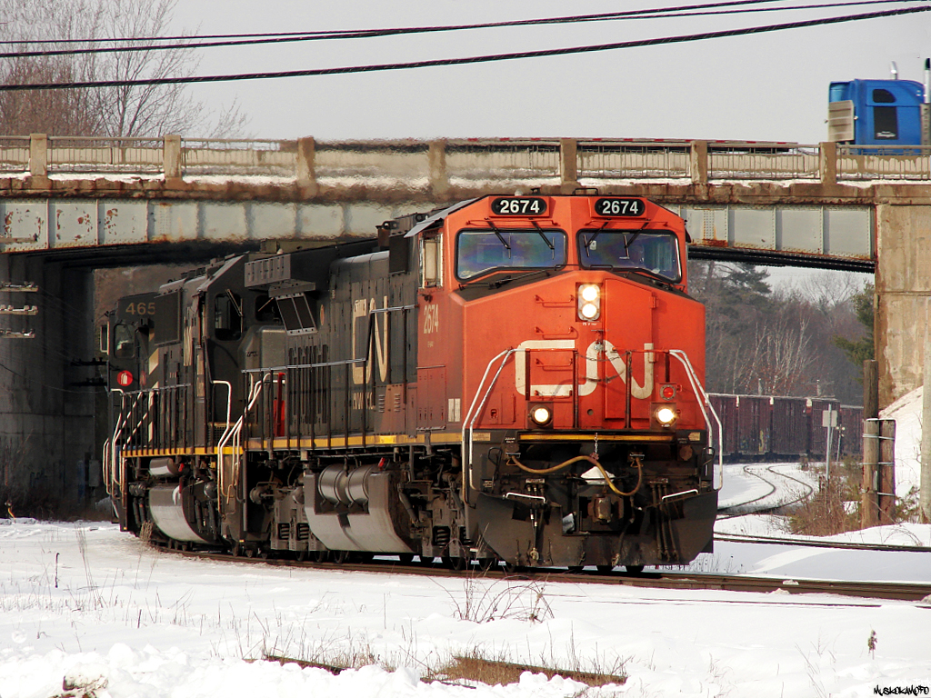 CN X31841 04 - CN 2674 South approaching a clear signal on the home at Washago, passing underneath Highway 11 with a train of extra traffic from Symington, filled out with a large cut of empty CWR flats on the tail end.