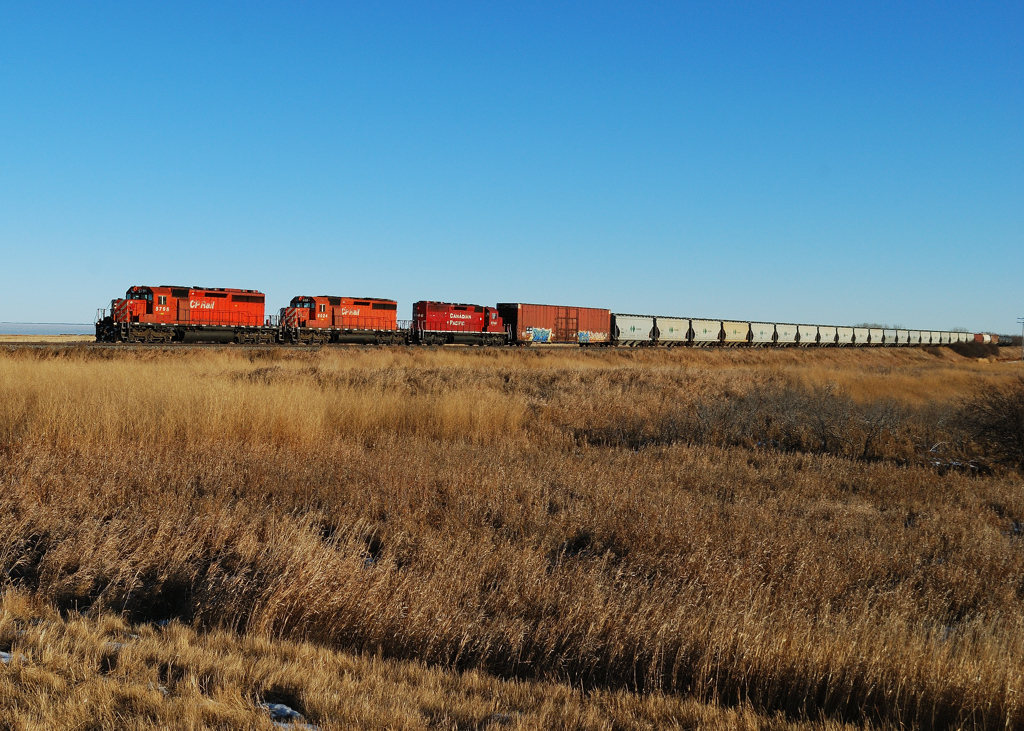 A trio of sd 40-2\'s make their way west towards Saskatoon. Off in the distance behind the lead unit is the massive Big Quill salt water lake.