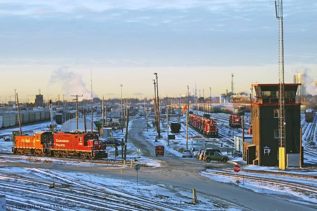 A frosty start to the day at Agincourt Yard a set of yard power sits along with a row of scrap units that have been sitting since May 2011.Beside the tower a unit is taking 3048 to replace 3114 on The Havelock Consist.