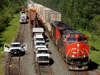 In the middle of isolation, CN Q10651 27 passes the entire switch gang, less a speedswing left at a jobsite at Argolis.