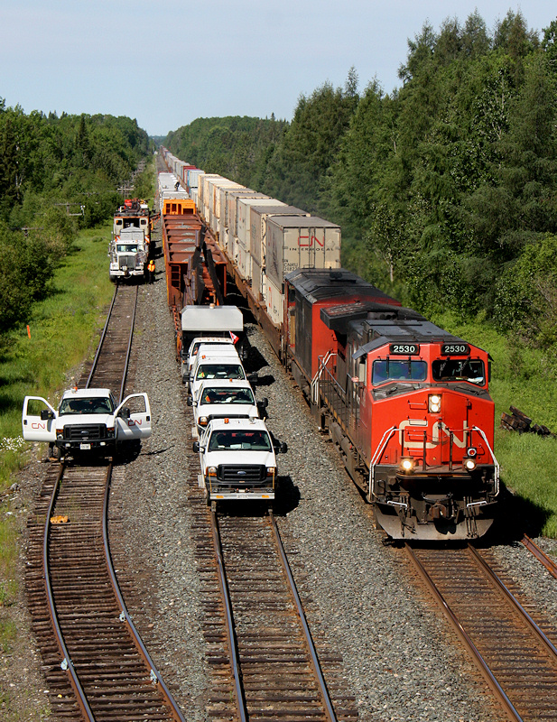 In the middle of isolation, CN Q10651 27 passes the entire switch gang, less a speedswing left at a jobsite at Argolis.