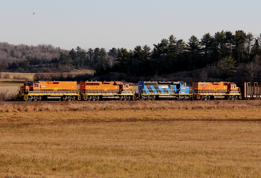 The rats are almost at the bar... A mixed sack of locomotives (HCRY, QGRY, DESX) click and clack at mile 150 of the Webbwood Sub with empty log & steel cars, and a few gons of scrap metal.