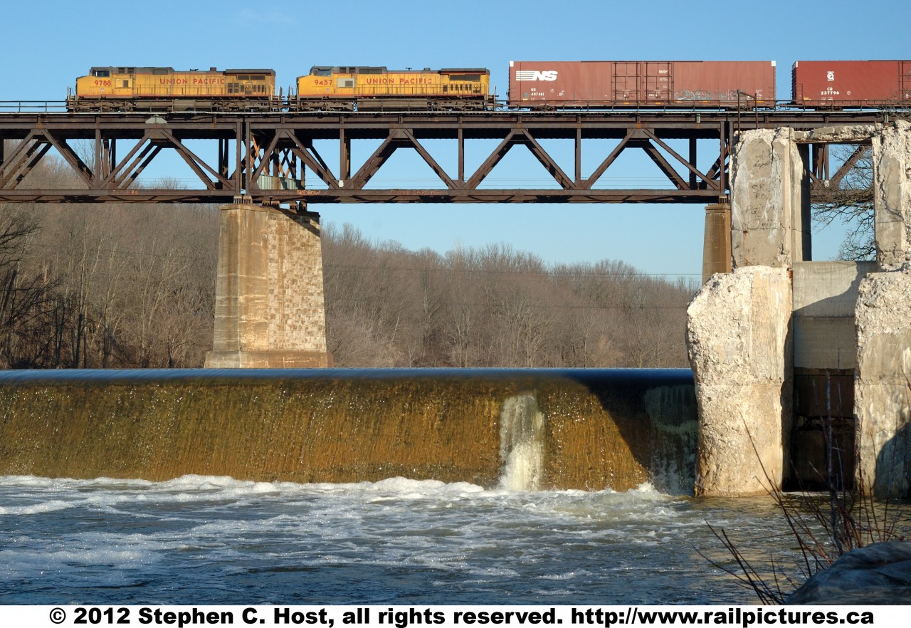 Here is Norfolk Southern train 327, Buffalo NY to St. Thomas, Ontario with two Foreign engines: UP 9788 and UP 9457. This yellow clad power pair leads the charge across the Grand River at Paris Ontario Canada, beside the ruins of an old water powered mill, in the waning days of the CN/NS \"Joint Section\" which, to this date had lasted 109 years and was scheduled to end at the turn of the new year..