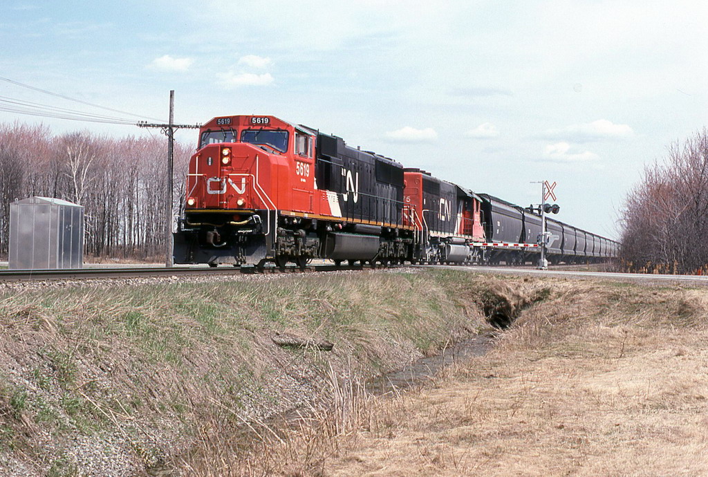 CN 309 with 5619 and 5375 pulls a long string of new TEGX hoppers.