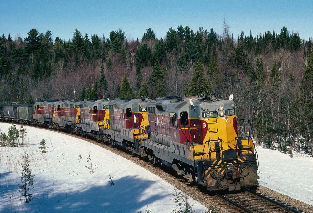 Extra 168 South has the white flags flying as it approaches the Sault. It was rare to see 5 GP7\'s on the ore trains at this time - usually the SD40\'s were used for this service.