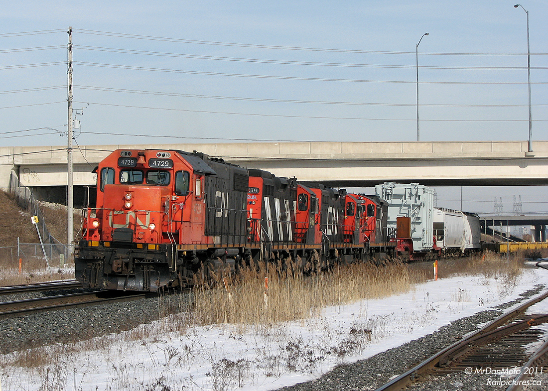 After shooting a detouring intermodal with a BNSF+Ferromex unit, and a solid army train special, I thought I had used up all my lucky charms of the day. And then this falls into my lap out of nowhere. CN 4729, 4139, 7026 and 7027 (sisters!) on a special dimensional move #547 with a large generator load pulling up to Bramalea GO station. There were employees following this movement, making sure the generator cleared the overpasses and signal bridges along the line.
