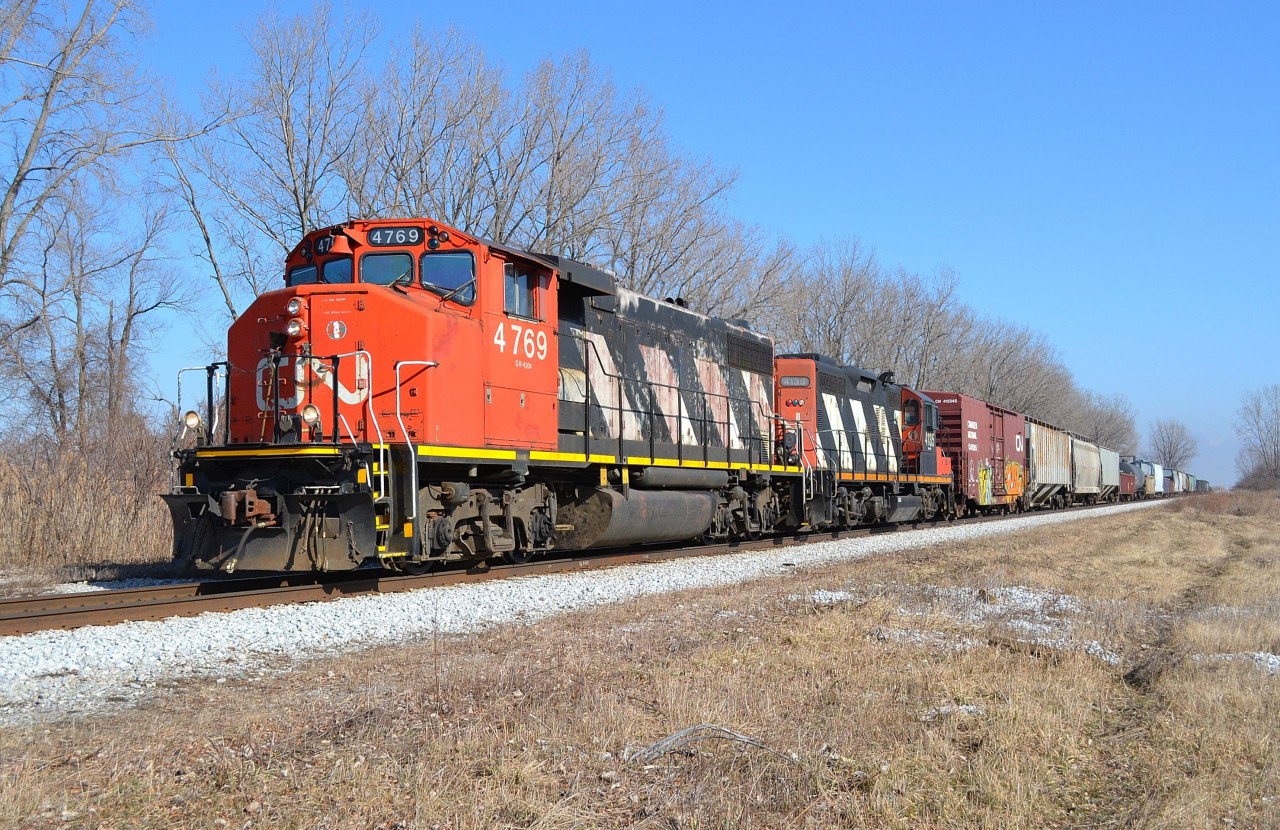 CN 439 led by a GP38-2W and a GP9RM, hauls this short mixed freight train westbound thru Jeannettes creek on its way towards Windsor.