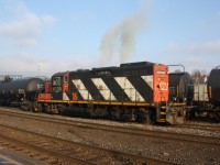 CN 4139 belching smoke as it accelerates with a cut of cars in the Brantford Yard