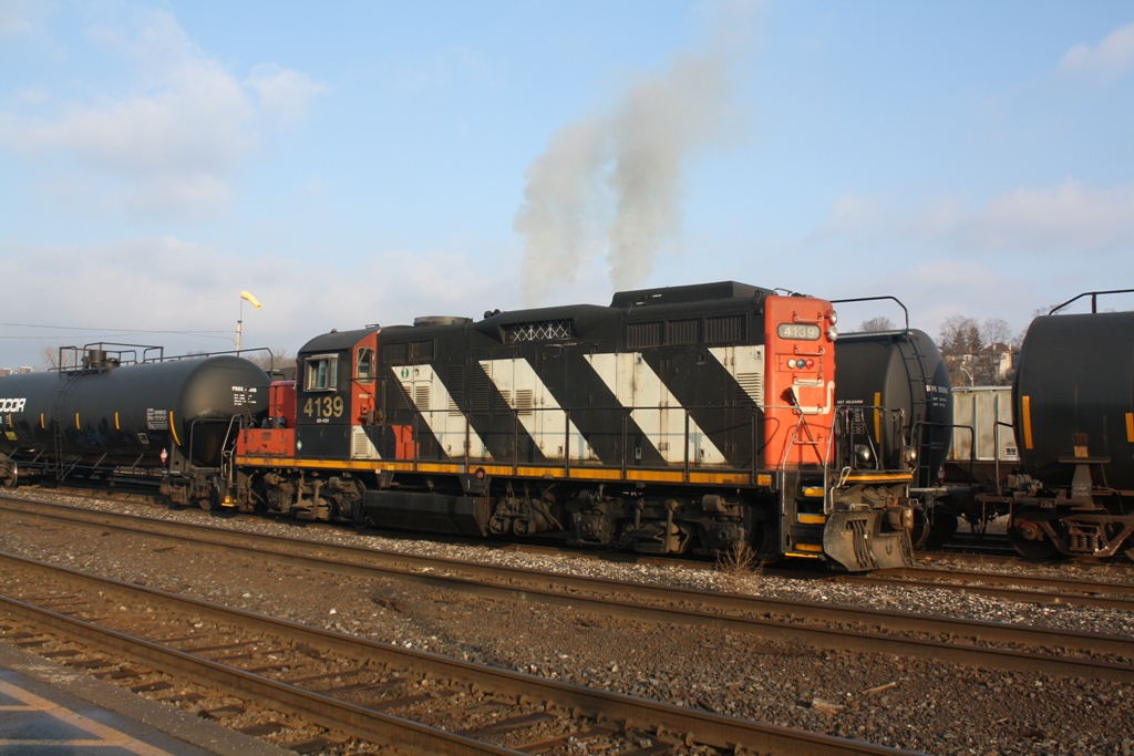 CN 4139 belching smoke as it accelerates with a cut of cars in the Brantford Yard