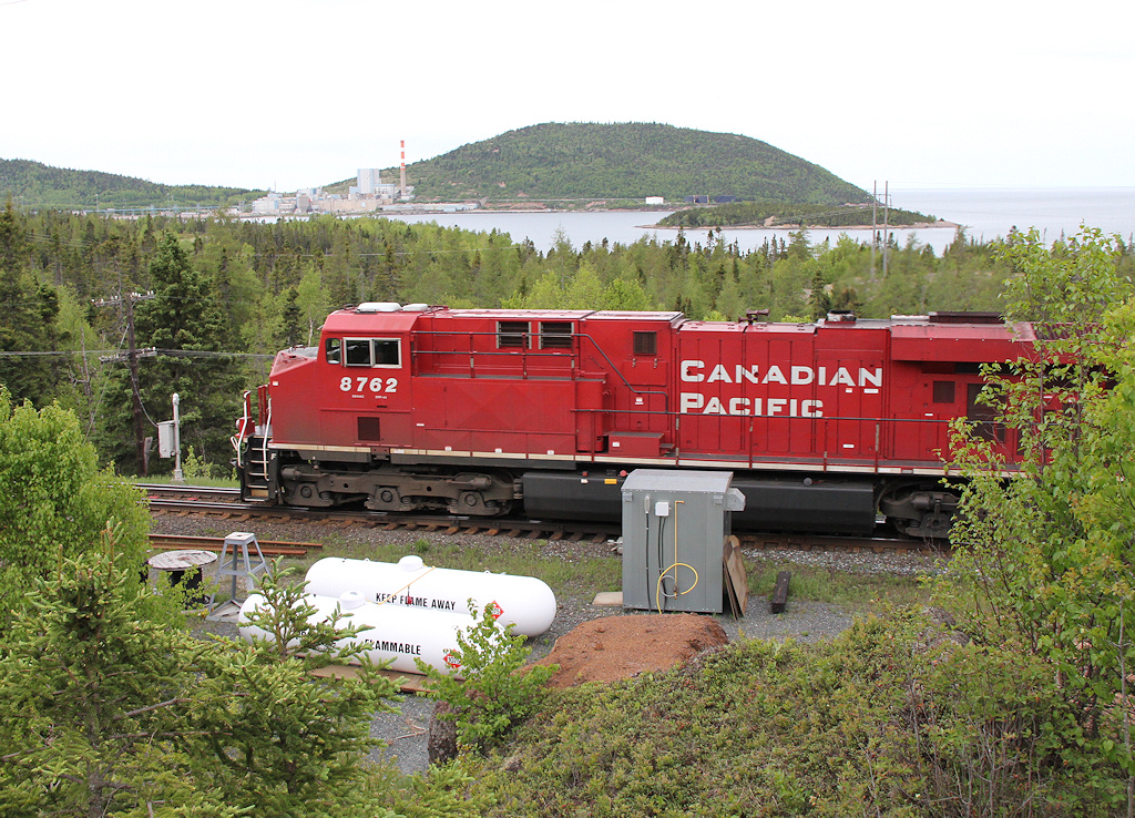An eastbound heads through the West OS track at Marathon with the closed Marathon Pulp mill and Lake Superior behind