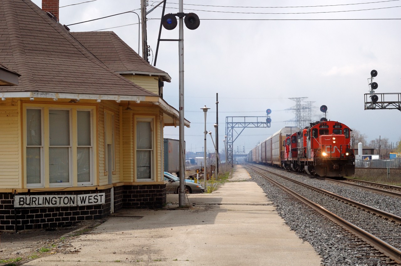 Burlington West: A CN eastbound freight is accelerating in a cloud of white exhaust mere days before the station at Burlington West is moved in preparation for a third track. Interestingly enough, the train order signal had not been used in nearly 20 years yet it was still in place until the end.