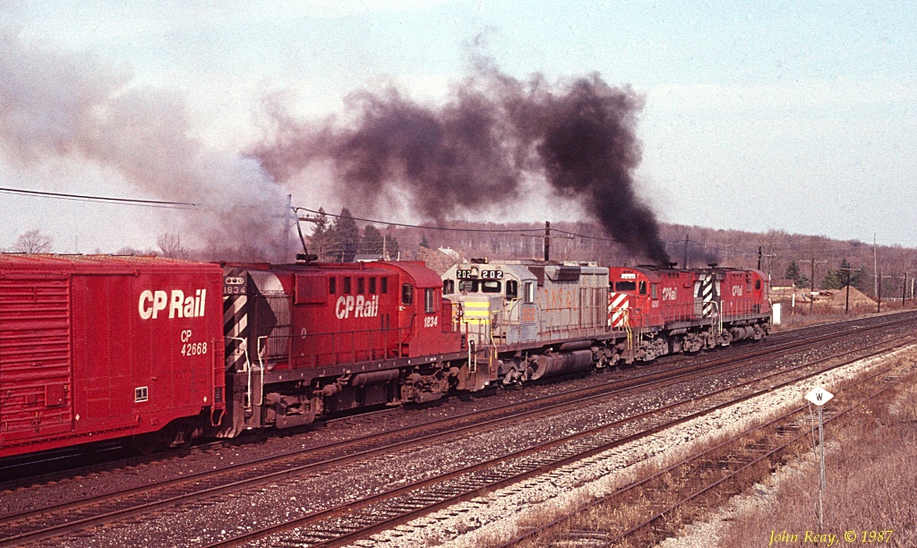 Having lifted RS-18 #1834, an eastbound blasts off from Guelph Junction in a cloud of MLW smoke. November 1987
