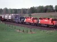 CP 955 north waits in the siding at Palgrave on the Mactier sub as a southbound, featuring Reimer Express TOFC behind the head-end, hustles through on the mainline. 