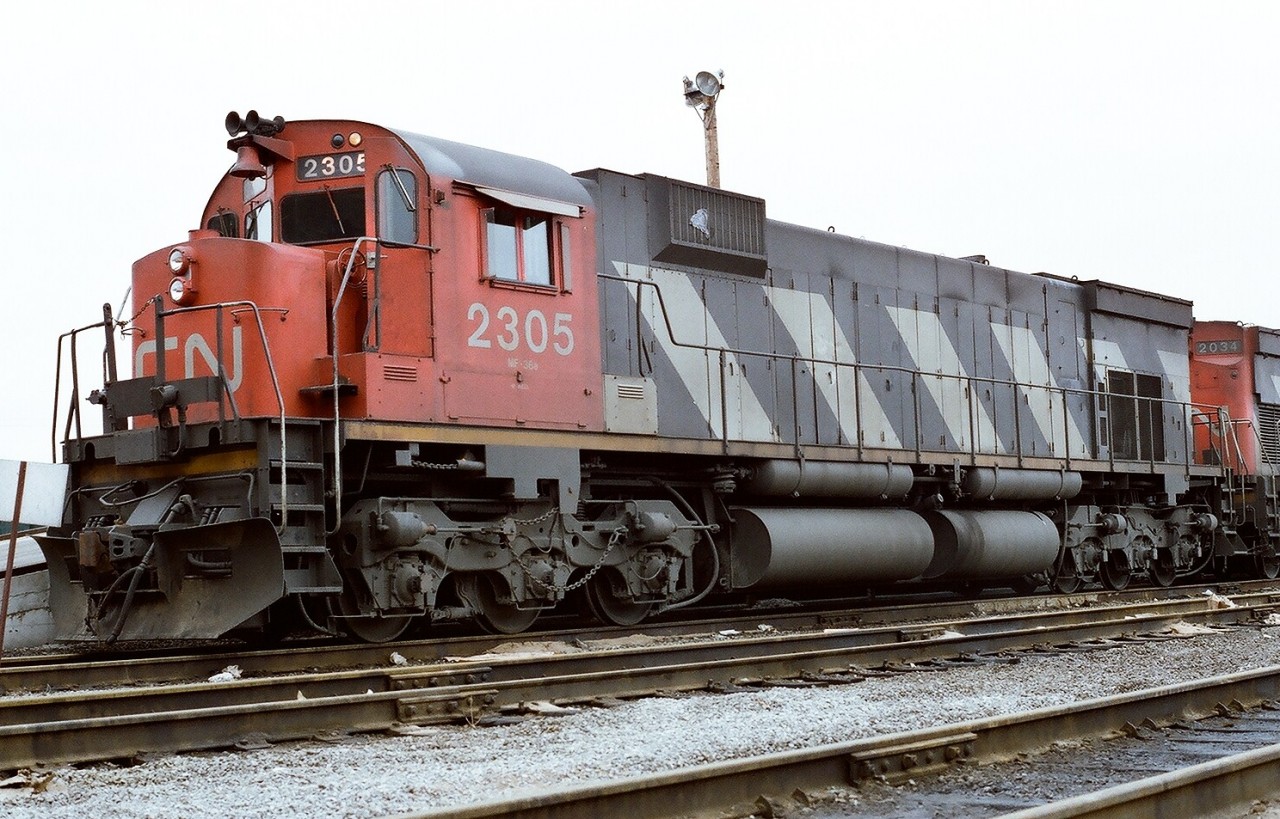 CN seventies super power idles at MacMillan Yard, Toronto awaiting next assignment: MLW M-636 2305 (retired by 1996) is paired with MLW C-630M 2034 (to CB&CNSR in 1993). Spring 1977 Kodak Kodacolor II ASA100  negative. Photographer S. Danko.