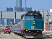 VIA 76 with 6446 sits beside the Windsor VIA station platform with the Detroit Renaissance Center in the background.