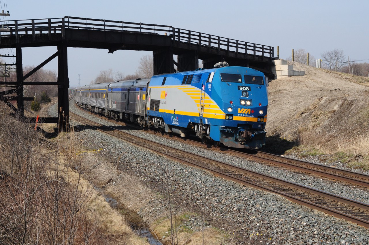 A wave from a friendly head end Via crew as Via #44 scoots under the recently rehabilitated ancient Lakeshore Road road bridge, mile 284.3 CN Kingston Subdivision,  13:07  March 22, 2012. Decades of old growth vegetation has been removed with CN installing fresh timber cribbing, new drainage and some new timber planking - and this bridge appeared old to this photographer in the 70\'s! (bridge must be really old by now!). One - one thousandths of a second \'shutter\' speed is barely sufficient to freeze the eighty plus m.p.h. ten year old P42DC Via #908 with six nineteen fourties era Budd built stainless steel cars (long live Budd!). Now if we can get GE and Via to match up those stripes! Nikon D5000 with a Nikkor 50mm F2 lens. Photographer S. Danko.