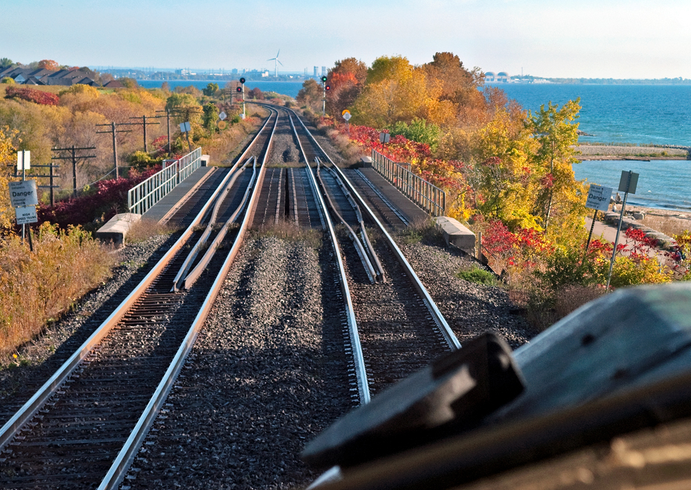 The early morning rush downhill on the Kingston Sub reveals Lake Ontario to the right and off into the distance the City of Pickering as we approach Rouge Hill GO Station just around the curve at Mile 319.