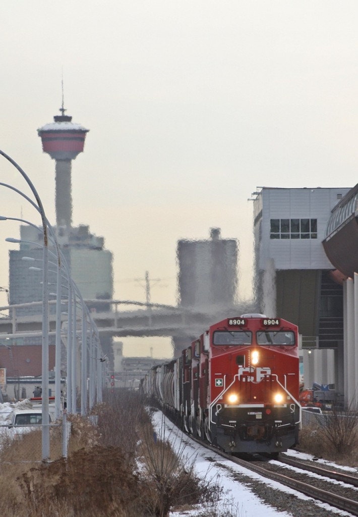 CP 8904 leads a manifest at Sunalta mp 1.5 on the Laggan Sub with the Calgary skyline in the background.