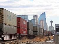 CP 112 heads into Calgary with a long train of containers as the skyline stands tall in the busy and always growing city.