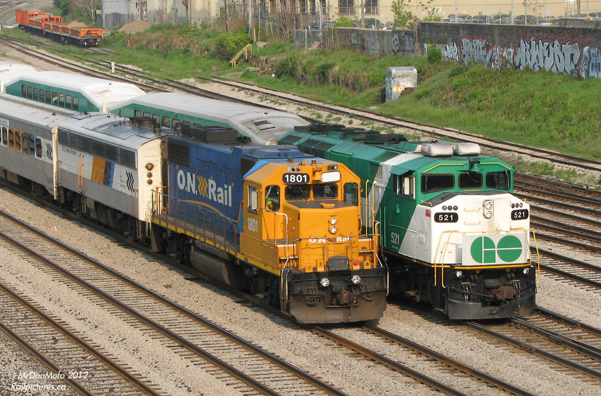 Different passenger power philosophies. While GO,  strictly a passenger agency, purchases dedicated passenger locomotives with built-in HEP generators, Ontario Northland prefers to use their freight units in passenger service, combined with an auxiliary power unit to provide HEP to the passenger cars. This is reflected with a meet of two passenger trains: the Northlander with ONT 1801 heading to Union Station to load its morning passengers, passing by GO 521 off #804 heading outbound at Bathurst Street.