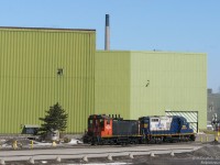 Waiting to get into US Steel's yard, Southern Ontario Railway 1359 (a recently reactivated ex-CN SW1200RS) and RLK GP10 1755 sit amid the gritty industrial green buildings of the former Stelco plant.