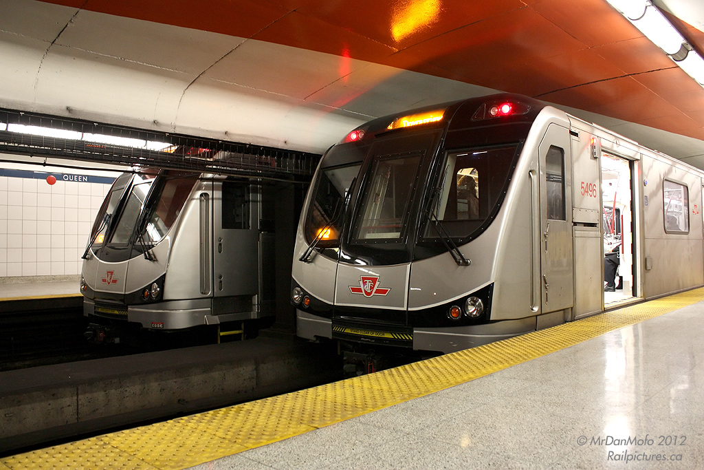 Pausing to switch crews, two Toronto Rocket consists with 5496 trailing northbound and  a sister heading southbound wait together at the TTC\'s Queen Subway Station.
