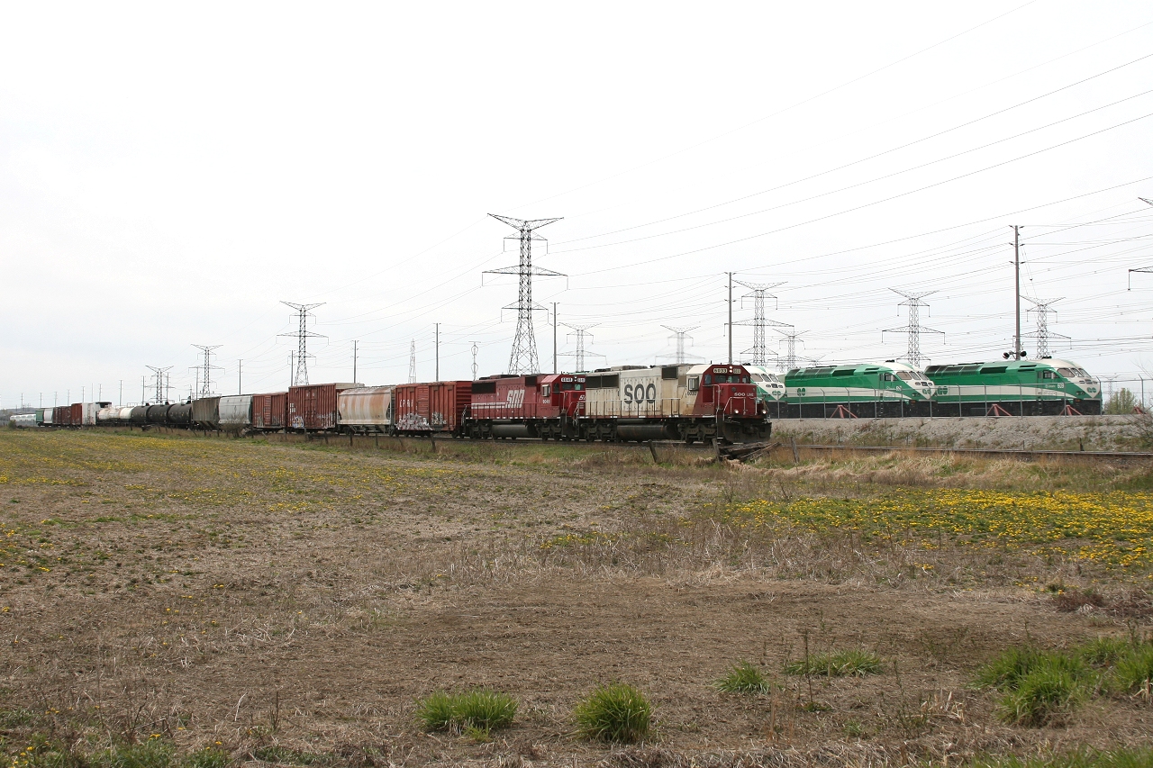 SOO 6033 and SOO 6048 cruise past the Milton GO Storage Yard with 18 cars