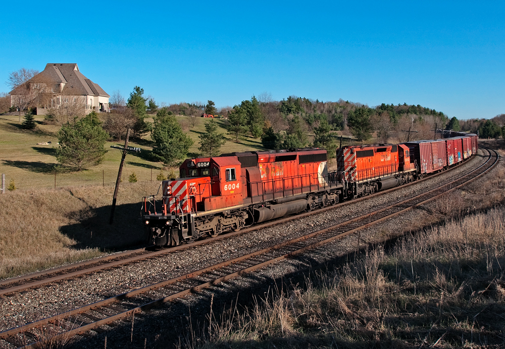 A pair of SD40-2\'s lead this Toronto to Sudbury freight through Palgrave on a sunny spring afternoon.