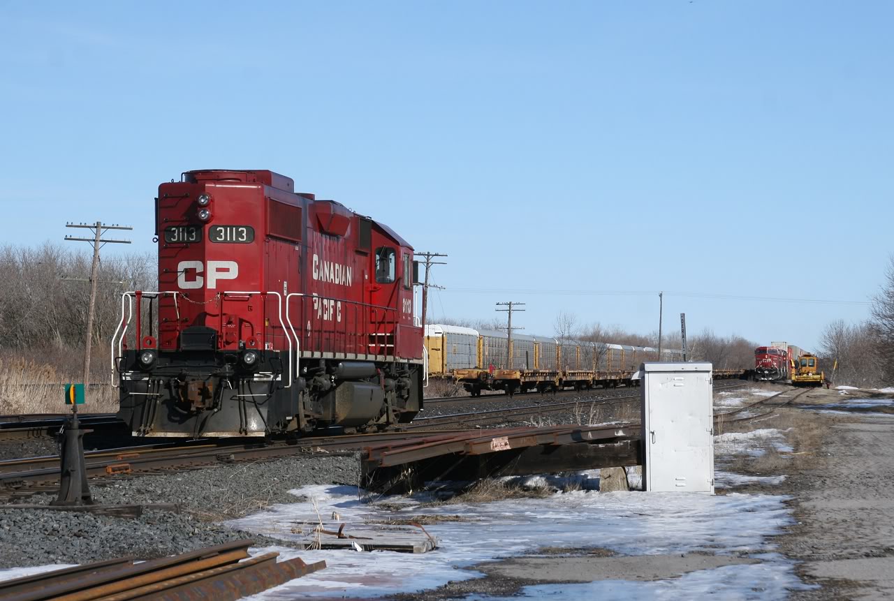 The Cobourg Turn and CP 235 sit in the siding at Brighton as CP 234\'s tailend rolls by on the main