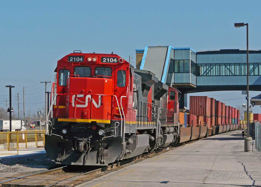 Awaiting the arrival of the outgoing crew, CN 149 sits just west of VIA Rail\'s new overhead bridge in Belleville.