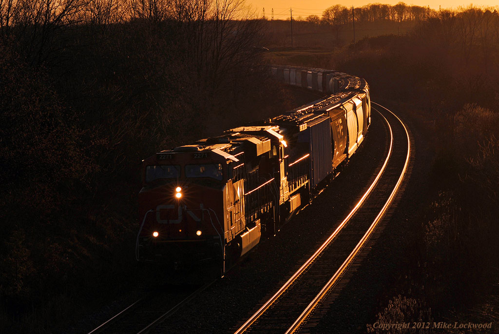 The setting sun glints off CN 2271 and 2129 as they lead 372 on the approach to Port Hope. 1922hrs.