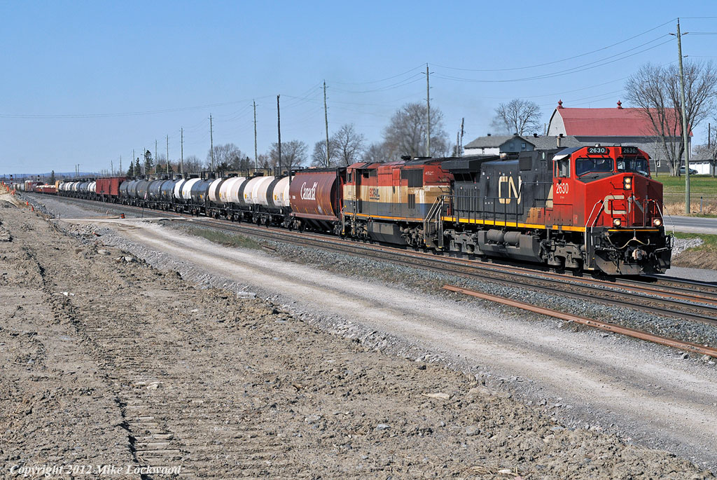 CN 2630 and BCOL 4620 lead train 308 out of the yard in Belleville and through CN Qunity. Work progresses on the construction of the third main track. 1125hrs.