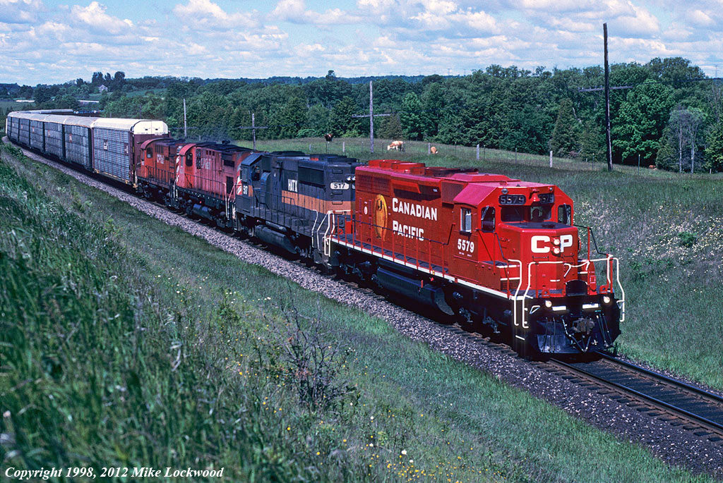 Freshly painted CP 5579 leads a motley assortment of power on 926 at Newtonville, Ontario. Trailing is HATX 517, CP 4204 and 1837, and within a month it would all be over for CP\'s remaining MLW fleet. Thanks to Gary Zuters for the heads up on this and a number of other notable consists as the MLW era drew to a close. 1030hrs.