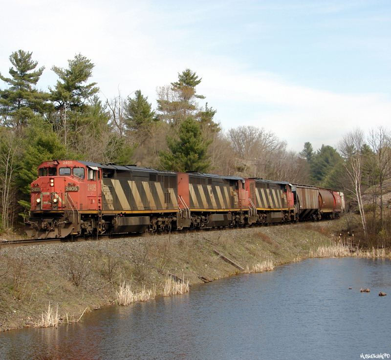 CN M30131 28 - CN 2405 North rounds the corner just North of Sparrow Lake at mile 94.5 Bala sub with an old school trio of C40-8CM\'s and 137 cars (9370 ft) worth of oversiding length train from Toronto\'s Mac yard. With the trio of Zebra striped wide-cabs and some of the older cars that have avoided graffiti, this was just like being back in 1998 for a few minutes.