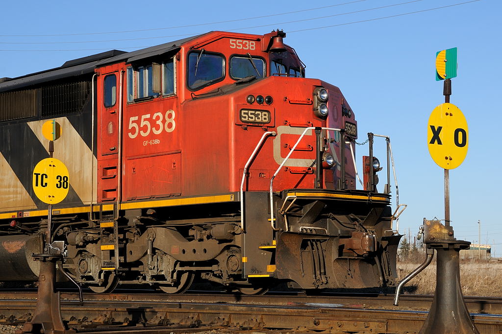 CN SD60F 5538 (and sister CN 5554 out of the frame) sits on the \"Northern Woods Lead\" on a beautiful April evening, framed between the TC38 and the crossover switches at the west end of the yard at Thunder Bay North.