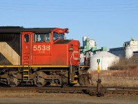 Basking on a warm spring evening, CN SD60F 5538 (and sister CN 5554 out of the frame) sit awaiting their next call to duty. In the background the elevators which are the CN's main source of business in Thunder Bay stand tall.