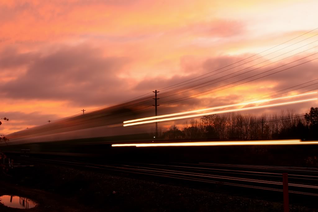 A GO equipment move streaks through Oakville at sunset.