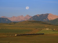 The moon sets over the Canadian Rockies at sunrise on September 22, 2002, at the Royal Canadian Pacific excursion train heads eastbound at Lundbreck, Alberta.