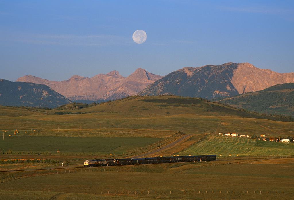 The moon sets over the Canadian Rockies at sunrise on September 22, 2002, at the Royal Canadian Pacific excursion train heads eastbound at Lundbreck, Alberta.