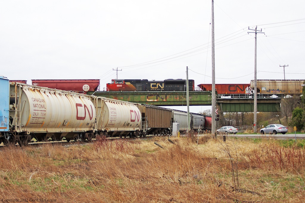 Peterborough Bound CN hoppers meet up with a Mac Yard Bound manifest in Box Grove.