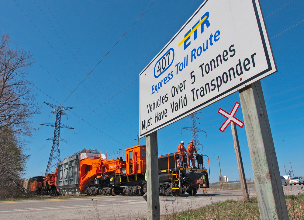 After protecting the crossing at Britannia Rd, the crew of the 8212 (cndr blocked by the sign) is about to board the Schanbel car again for the ride south to protect the final crossing and then onwards to the Hydro One substation.