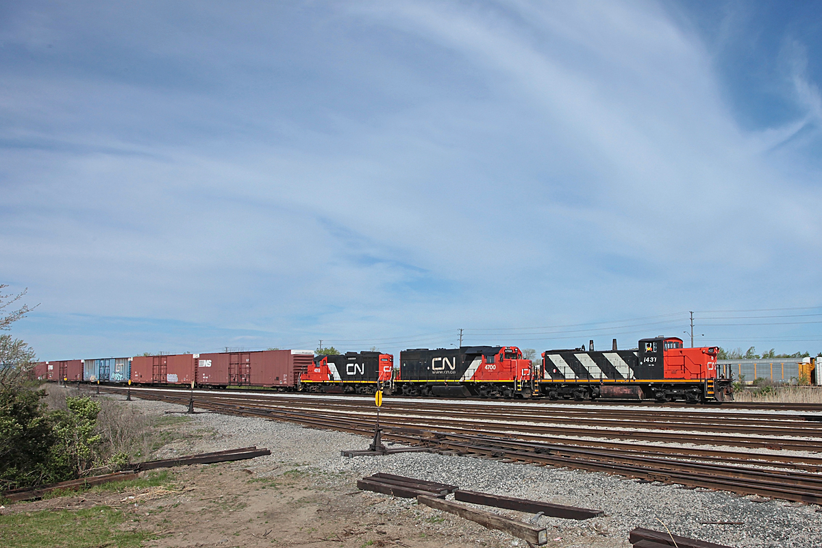 Three fine-lookin\' GMDs led by GMD1u 1437 push boxcars up the hill from Oakville Yard to the Ford Assembly Plant on a warm and breezy spring day.